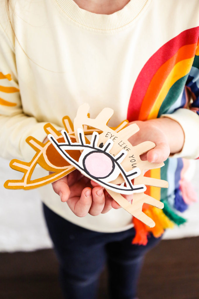 DIY wooden valentines held in the hands of a little girl